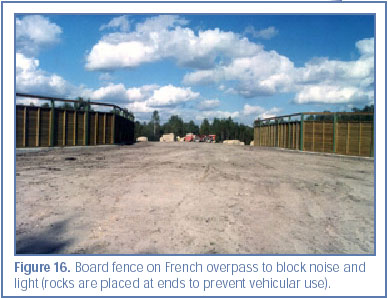 Figure 16. Board fence on French overpass to block noise and light (rocks are placed at ends to prevent vehicular use).