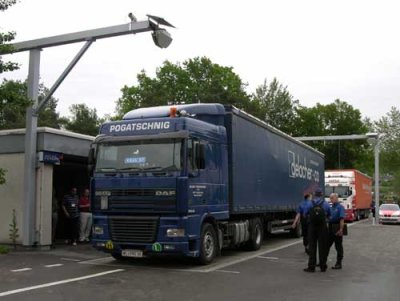 Photo of commercial trucks stopped at a Swiss fixed weight and size facility with a vehicle profiler system.