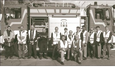 Scan team in front of Mont Blanc Tunnel firefighting truck. Standing (left to right)are two Mont Blanc hosts, team member Chris Hawkins, Mont Blanc host, and team members Mike Swanson, Mary Lou Ralls, M.G. Patel, Steve Ernst, Jesus Rohena, Harry Capers, Tom Margro, and Gary Jakovich. Kneeling are team members Don Dwyer and Wayne Lupton.