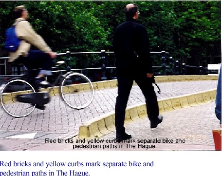 Red bricks and yellow curbs mark separate bike and pedestrian paths in The Hague