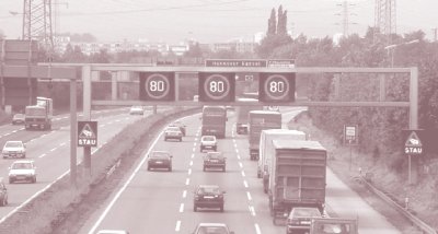 Photo of traffic passing under a gantry displaying pictographs indicating congestion ahead.