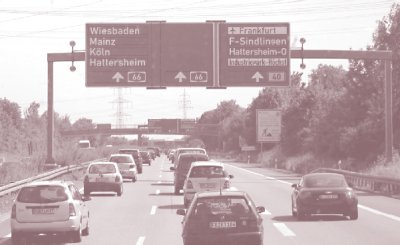 Photo of traffic passing under a prism guide sign that changes with traffic conditions in Germany.
