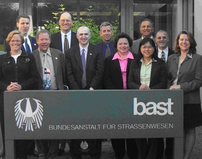 Photo of scan team members standing behind BASt sign in Bergisch-Gladbach, Germany: (left to right) Robin Mayhew, Jon Obenberger, Chuck Fuhs, Ray Krammes, Mohammad Mirshahi, Craig Stone, Meg Moore, Jessie Yung, Khani Sahebjam, Charlie Howard, and Beverly Kuhn.