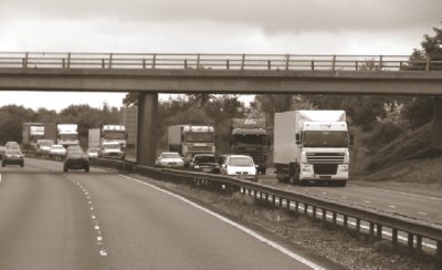 Photo of concrete road with thin asphalt surfacing in England.