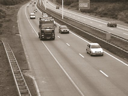 Photo of jointed concrete motorway pavement in the Netherlands with full-width outer shoulder as emergency lane.