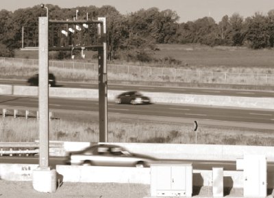 Photo of vehicle passing under electronic sensors on gantry at on-ramp to 407 ETR.