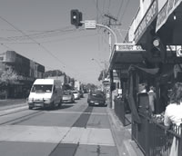 Photo of a midblock pedestrian-actuated crossing with pedestrian fencing.