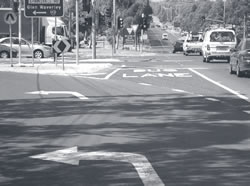 Photo of colored pavement used to mark a bus queue-jump lane at a signalized intersection.