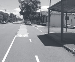 Photo of colored pavement used to highlight a bicycle lane as it crosses an unsignalized intersection.