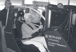 Photo of scan team members testing the Monash University Accident Research Centre driving simulator.