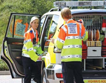 Figure 3. Photo of two traffic officers standing next to a Highways Agency vehicle.