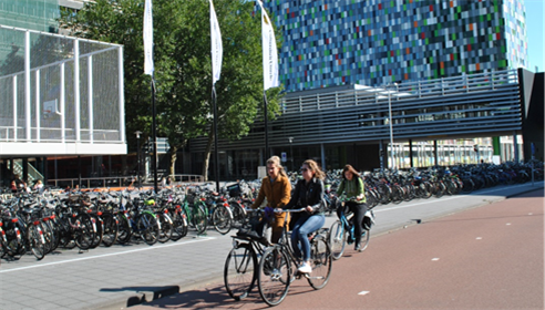 Figure 26 De Uithof, Utrecht - Description: Three women riding their bike with a full bike rack beside them