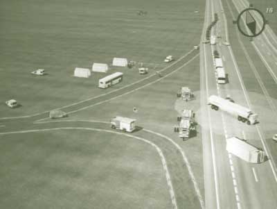 Titled "Bird's Eye View," this computer rendered image depicts the scene following a highway accident involving a tanker truck and a delivery van (overturned). The image depicts several on-site shelters set up along the roadside, with emergency vehicles in attendance.