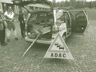 Titled, "ADAC vehicle," this photograph shows the rear of an ADAC van with the doors opened and an ADAC branded triangular warning marker.
