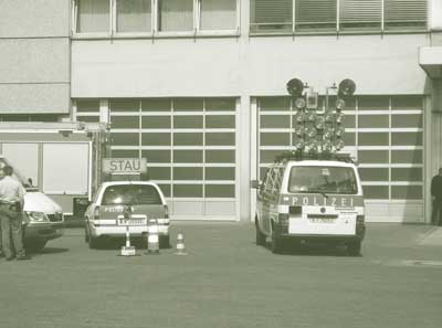 Rear views of two vehicles, one equipped with static signage, and one with lights.