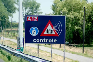 Photo of roadside sign indicating photo enforcement of highway speeds.