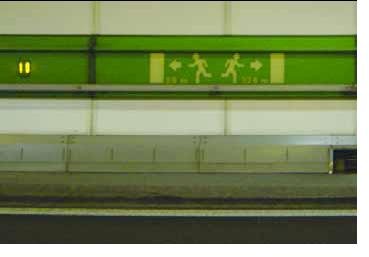 A green strip is shown running the length of the tunnel with arrows and painted figures running in the appropriate direction for an emergency/escape.