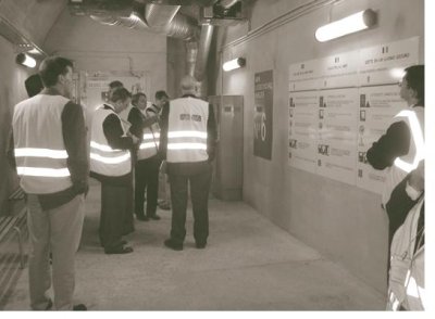 Men in reflective vests gathered in the refuge room reading the instructions posted on the wall.