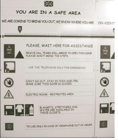 Photograph of instructions on the wall of the refuge room indicated that it is a safe area. Pictures are listed along each side vertically with text in between providing instructions for safety and rescue.